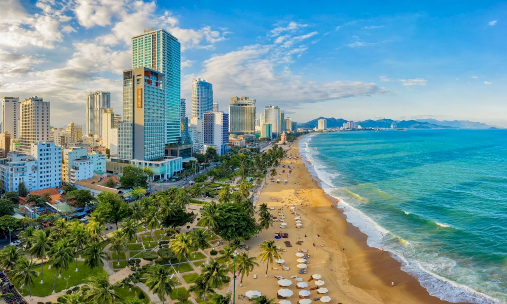 The Nha Trang Beachfront Promenade charms with blue waters, soft sands, and swaying coconut palms
